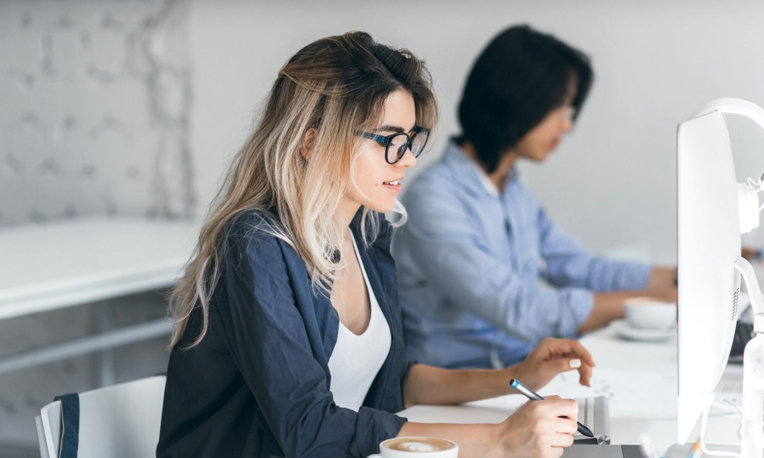 Finanzanalyst arbeitet mit Geschäftsberichten und Taschenrechner